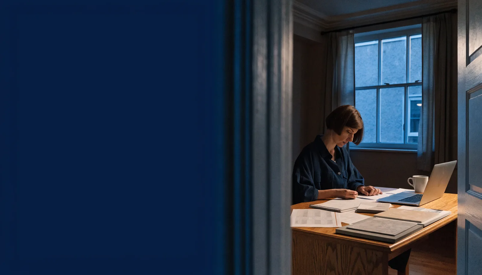 Illustrative scene of a business owner working at a desk after hours.