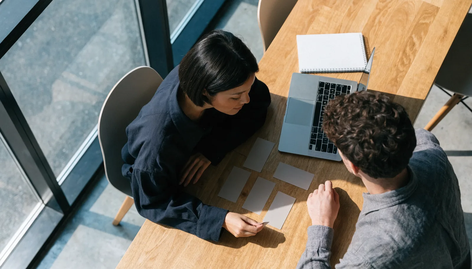 Illustrative scene of two people mapping a process together at a modern office table.
